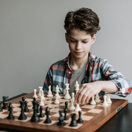 73_9282_05Jun2023153943_Young boy playing chess 540px.png
